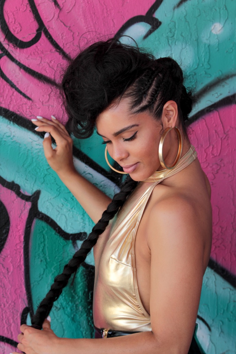 Model wearing a braided updo with a single long braid, styled by Hair by Alexy in Raleigh, NC